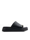 Schwarze Flatforms Goldenelement am Zeh